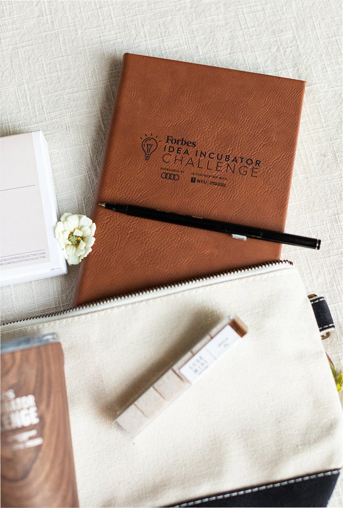 Brown notebook with 'Idea Incubator Challenge' branding on a light surface.