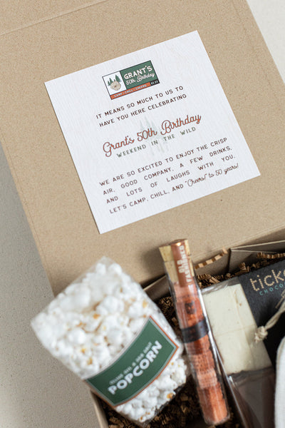 Gift box from The Lux Box Co with a card reading, "Grant's 50th Birthday" and themed items: popcorn, candle, and chocolate. Perfect for gifts for social events or corporate gifting.