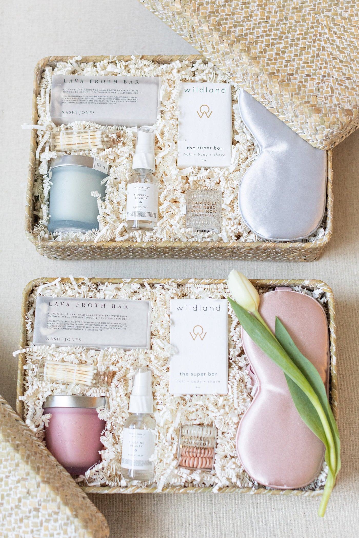 The LUX BOX Spa Gift Box - Grey includes two baskets with skincare products, a silk sleep mask, and a tulip. These carefully arranged items come on shredded paper inside sleek woven baskets with lids, designed to enhance your self-care routine.
