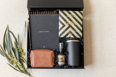 Introducing LUX BOXs The Corporate Suite Gift Box: a luxury collection with a notebook, coffee bag, pencil, leather pouch, Focus Boosting Spray, and insulated tumbler. Adorned with green leaves, its designed to boost productivity in style.
